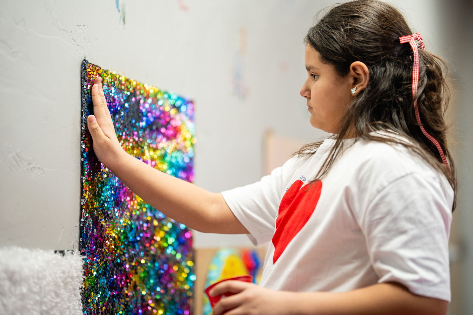 Young girl engaging with a colorful sensory wall at Mariposa Autism Service Center, designed to support emotional regulation.