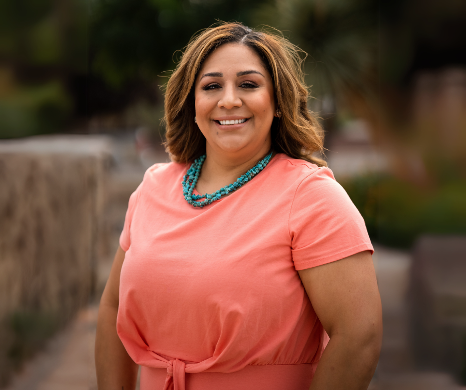 Brenda Miranda at the Aprendamos office smiling for the camera.