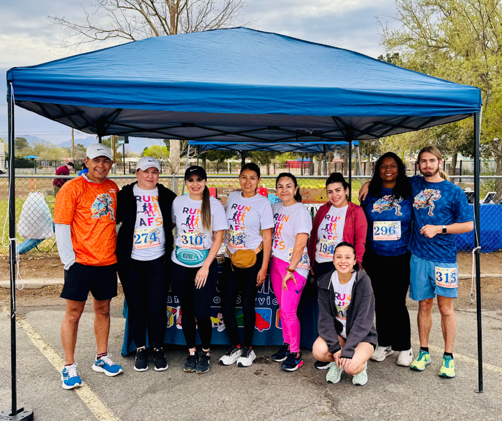 Aprendamos Family of Services team wearing “Run with AFS” shirts at a Heart for Autism Awareness race.