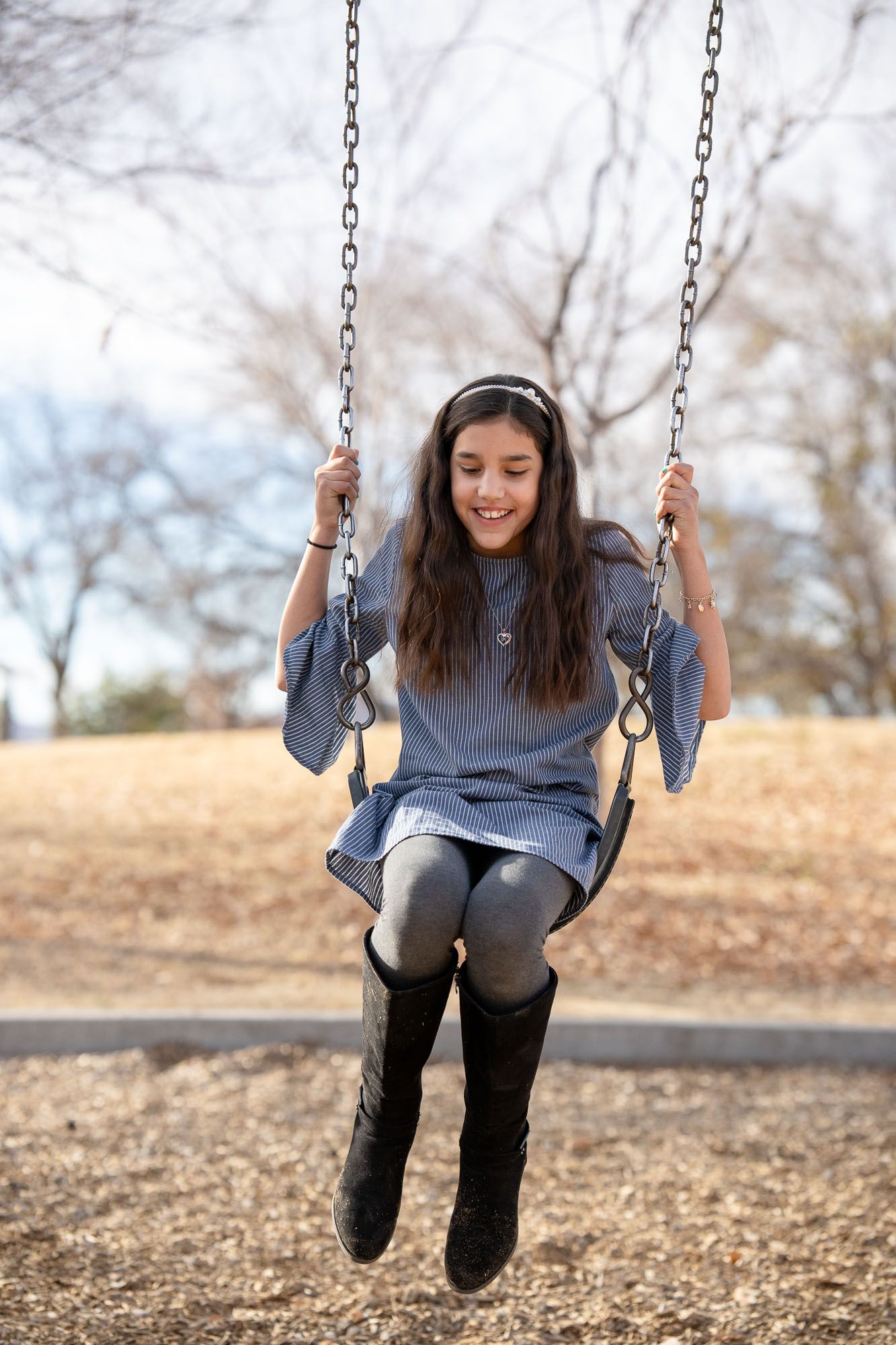 Young girl smiling on a swing during a peaceful outdoor moment, reflecting the emotional wellness.