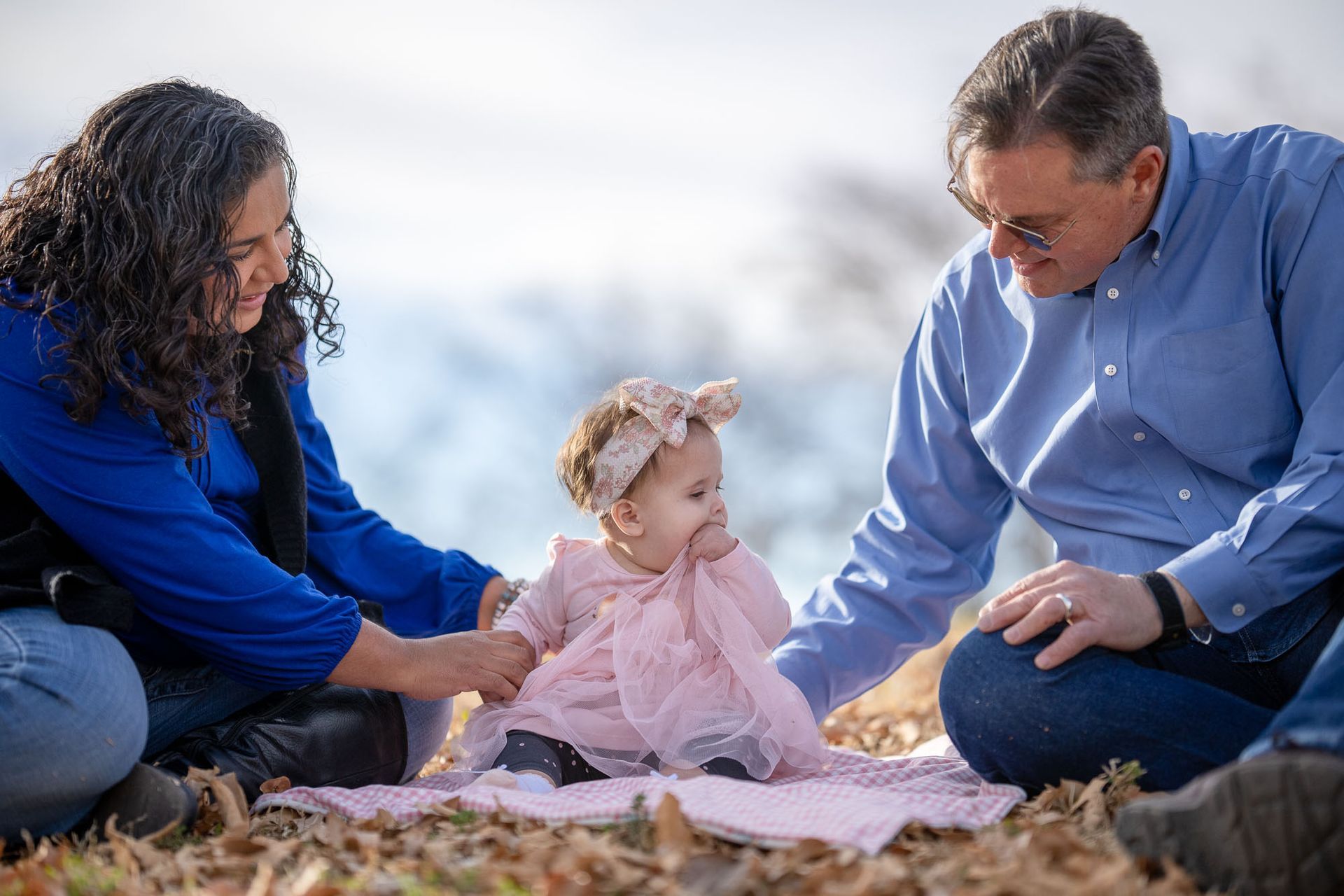 Baby Elizabeth sitting outdoors with her family during an Aprendamos Early Intervention moment.
