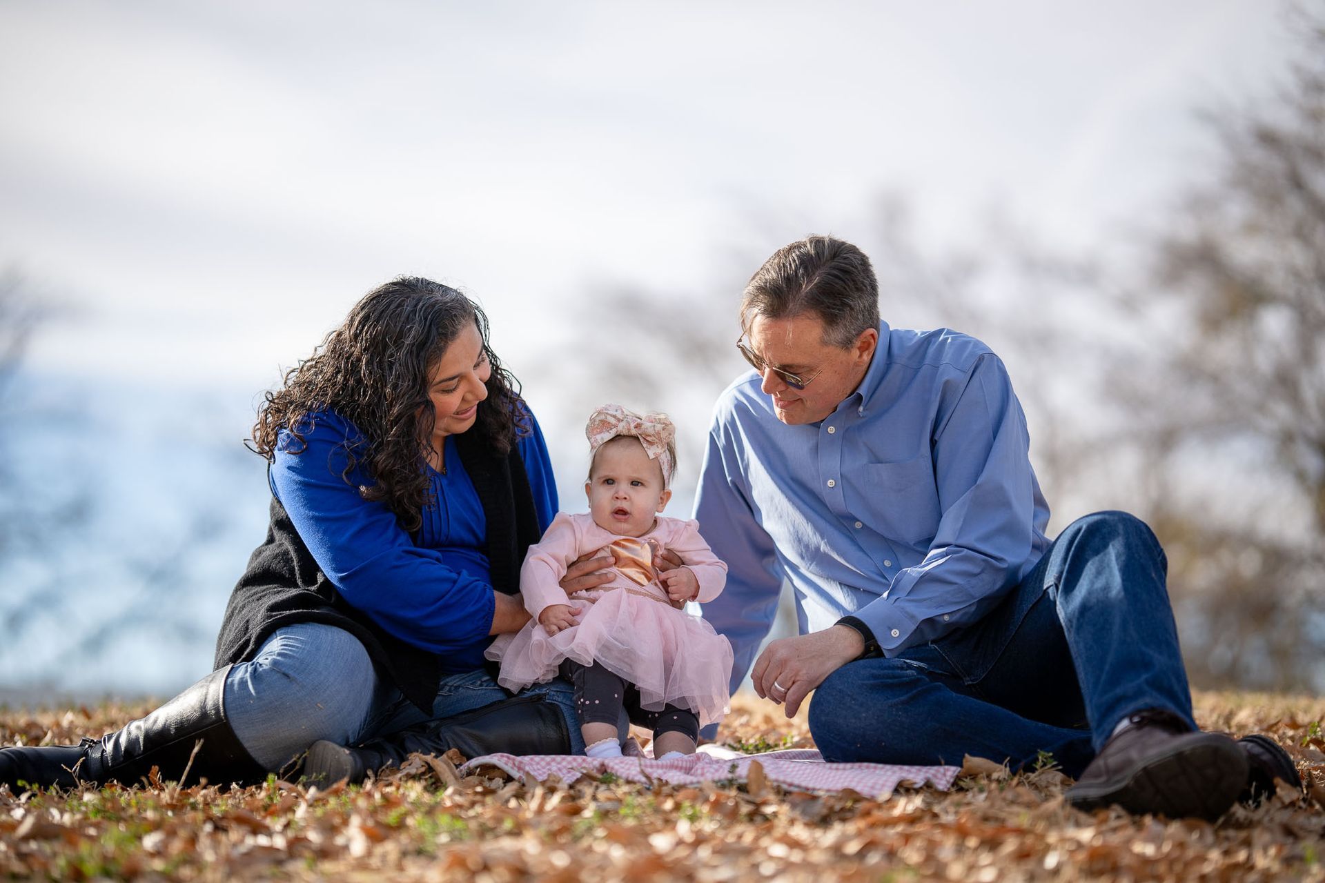 Family sitting outdoors with their baby daughter Elizabeth during a Cariño Home Visiting session.