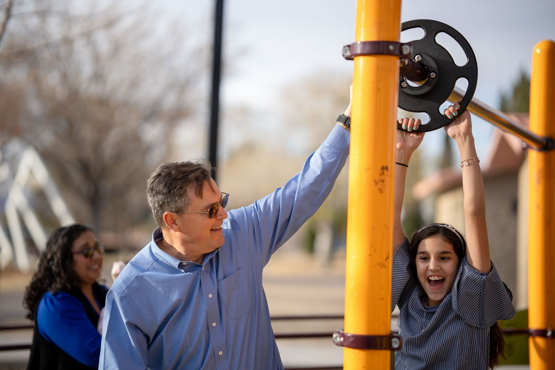 Father sharing a joyful moment with his daughter on a playground, capturing the essence of the Conscious Fathering Program.