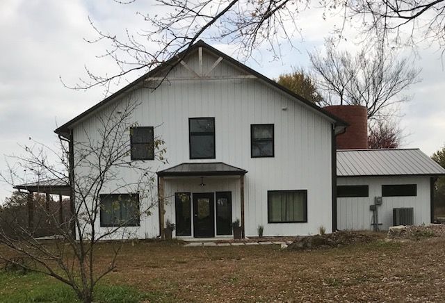 A large white house with a black door and windows