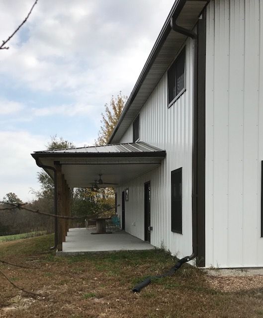 A white house with a porch on the side of it