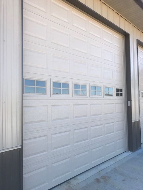 A white garage door with a lot of windows on it