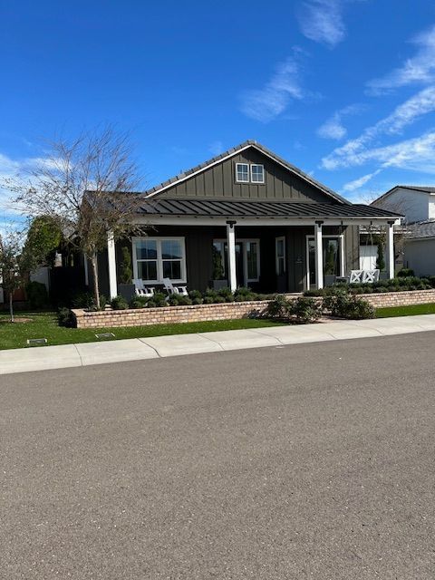 A house with a porch and a blue sky in the background