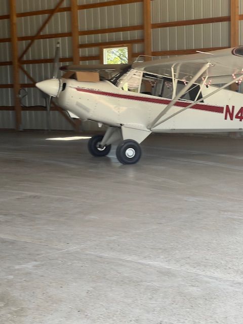 A small plane with n4 on the side is parked in a hangar