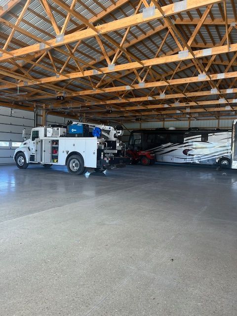 A fire truck is parked in a garage next to a rv.