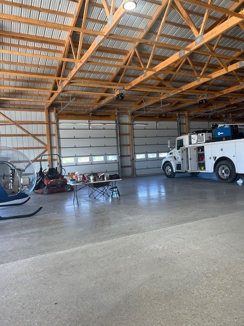 A helicopter is parked in a garage next to a truck.
