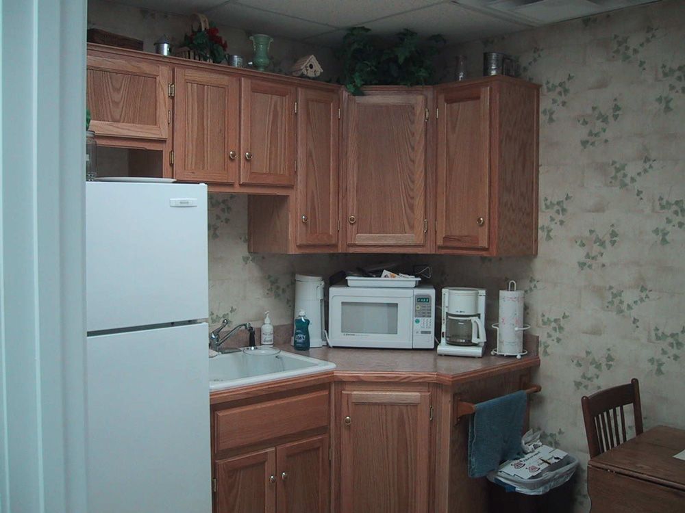 A kitchen with wooden cabinets and a white refrigerator