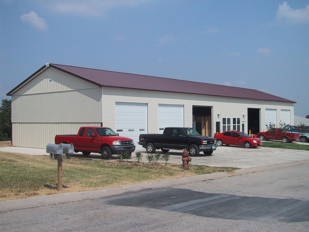 A red truck is parked in front of a garage