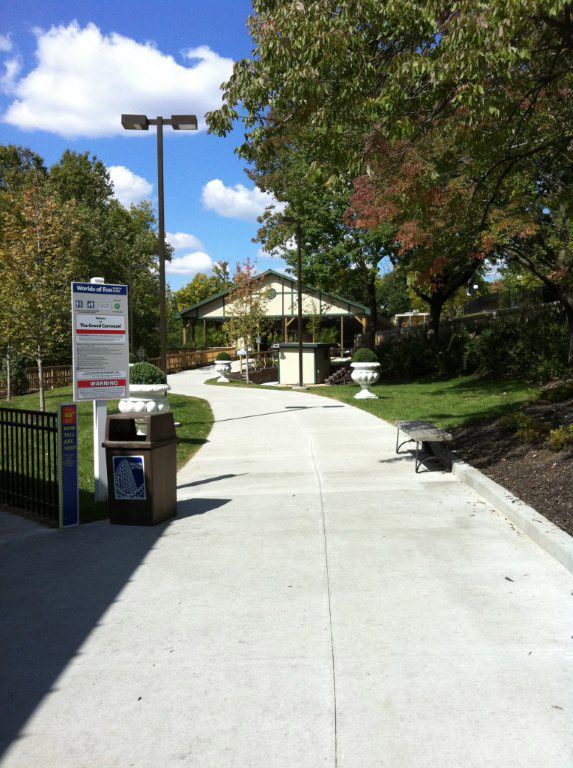 A concrete walkway leading to a building with a sign that says 
