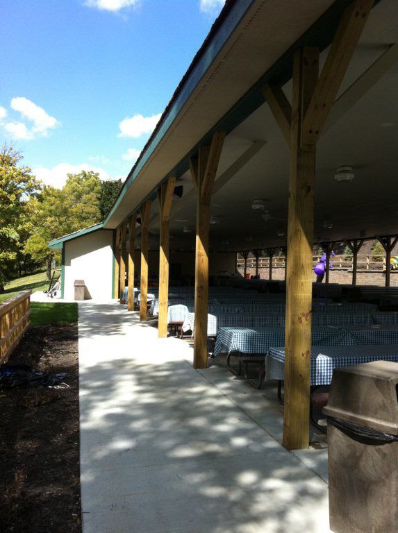 A covered area with tables and chairs under a roof