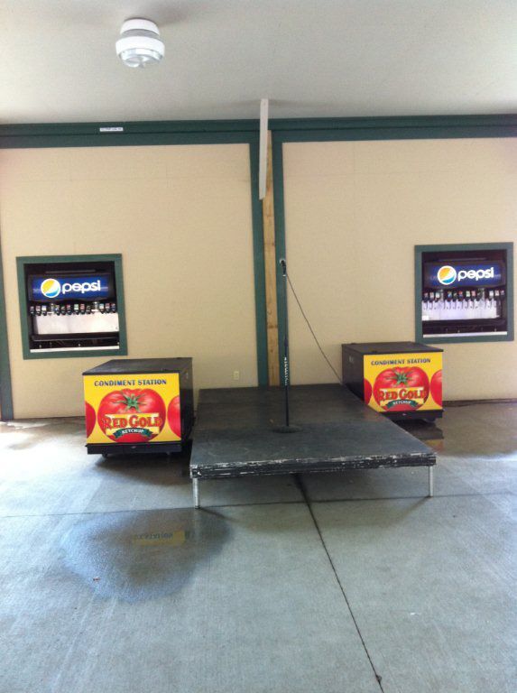 A pepsi sign is on a wall next to a tomato sign