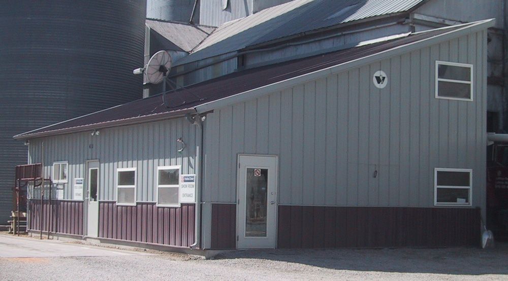 A gray and brown building with a white door