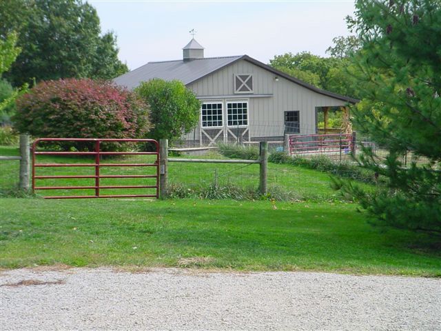 A barn with a red gate in front of it