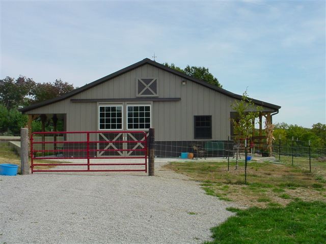 A barn with a red gate in front of it