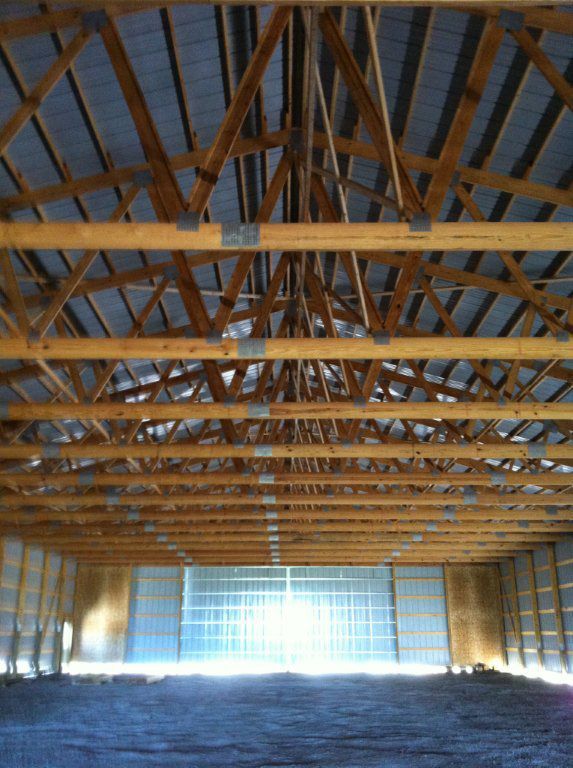 The ceiling of a building with a lot of wooden beams.