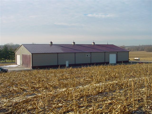 A large building in the middle of a corn field