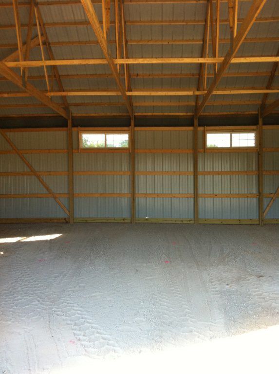 A large empty building with wooden beams and a roof.