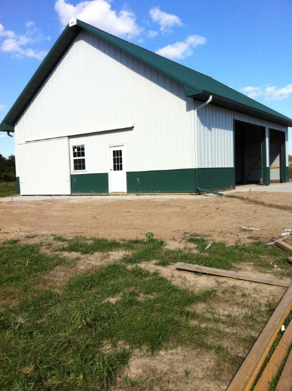 A large white barn with a green roof