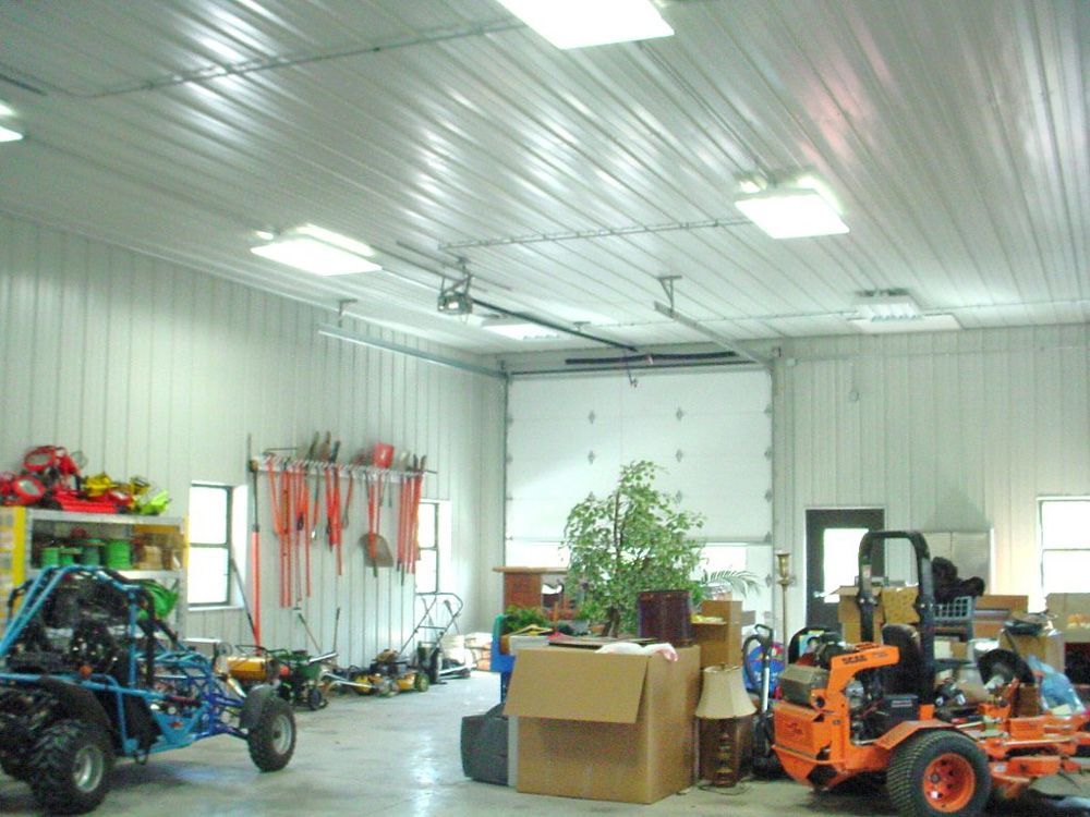 A garage with a lawn mower and a buggy