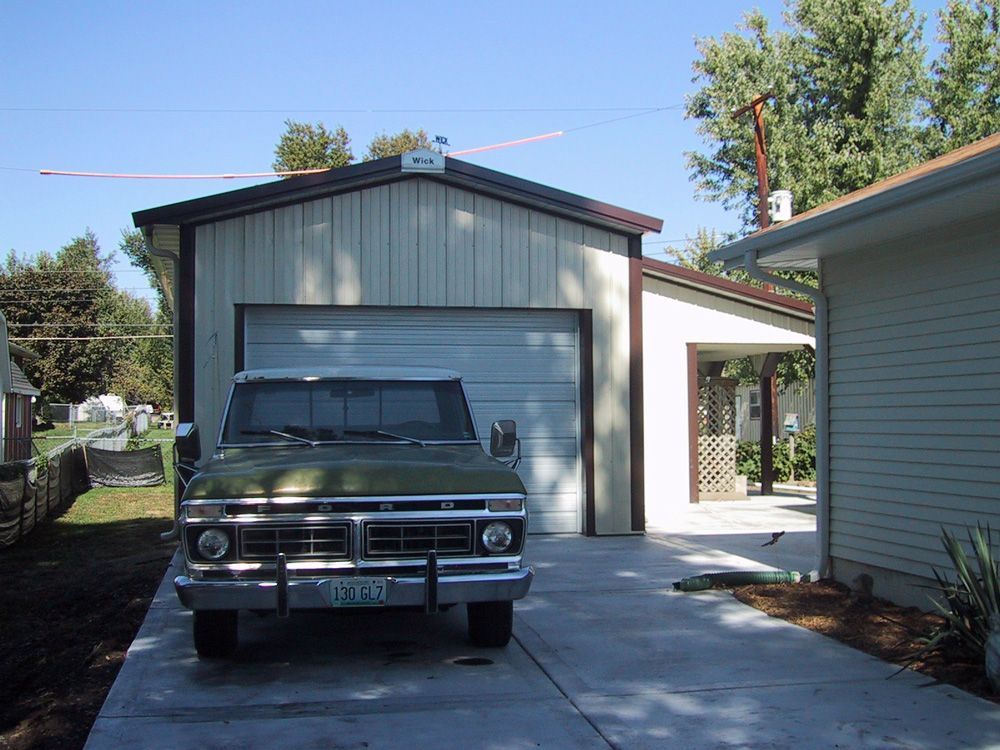 A ford truck is parked in front of a garage