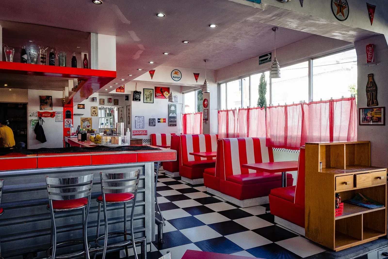 Un restaurante con cabinas de rayas rojas y blancas y un suelo a cuadros.