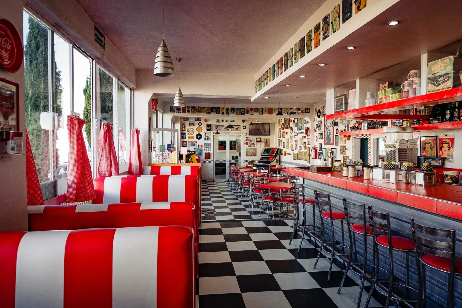 Un restaurante con asientos a rayas rojas y blancas y suelo a cuadros.