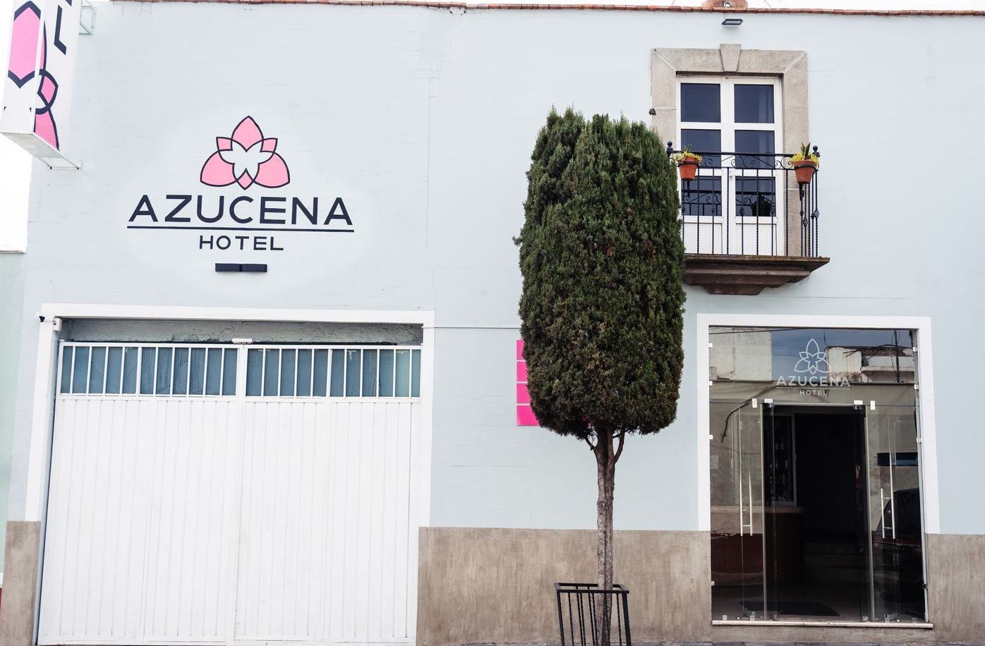 Un edificio blanco con un cartel que dice hotel azucena