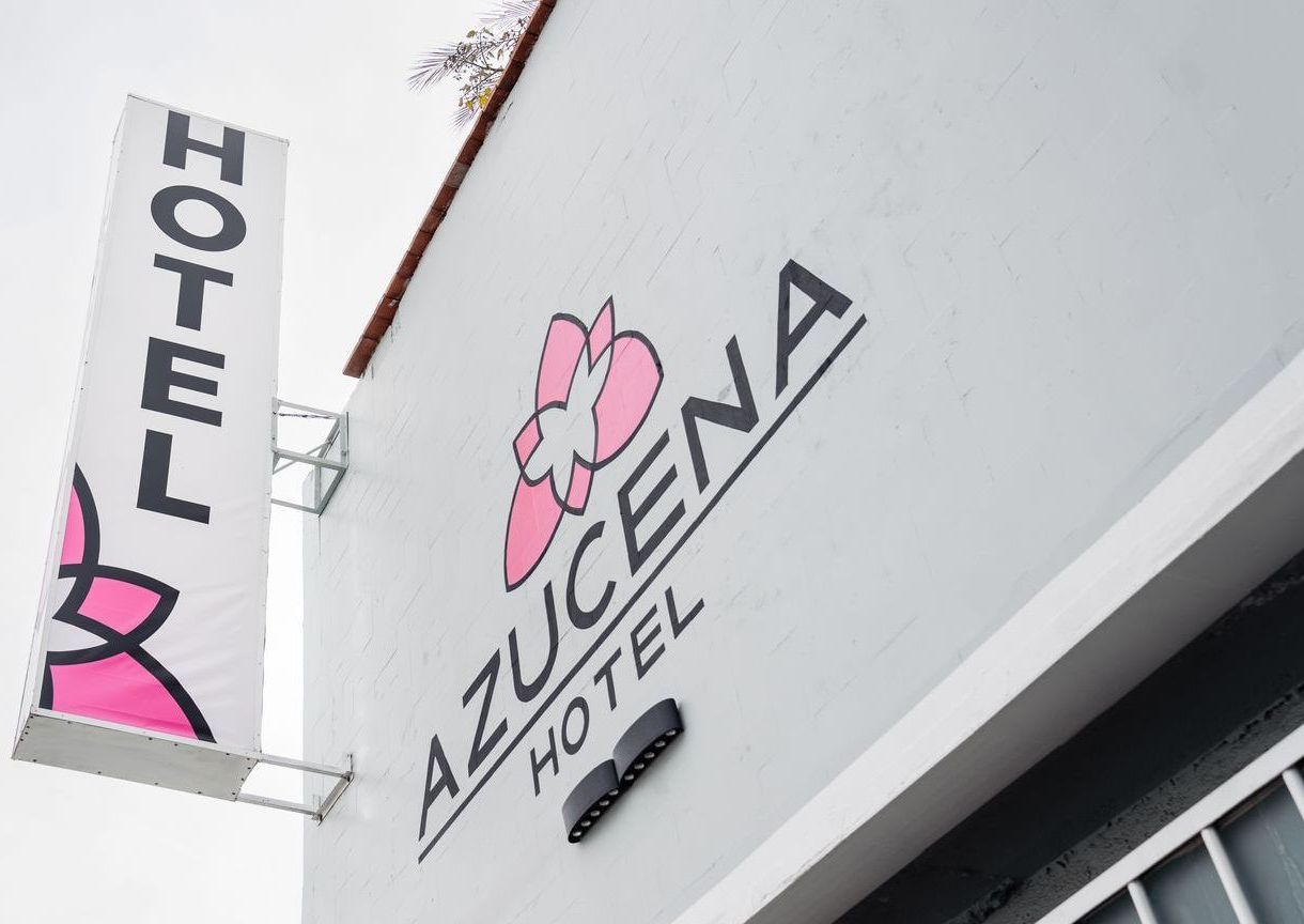 Un edificio blanco con un cartel que dice hotel azucena hotel