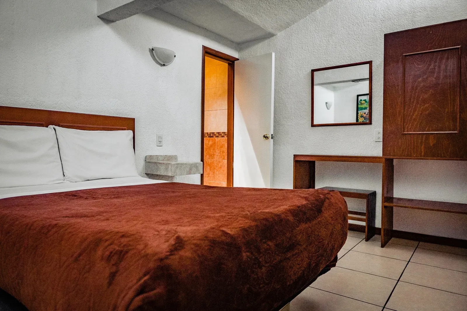 Una habitación de hotel con una cama y un espejo.