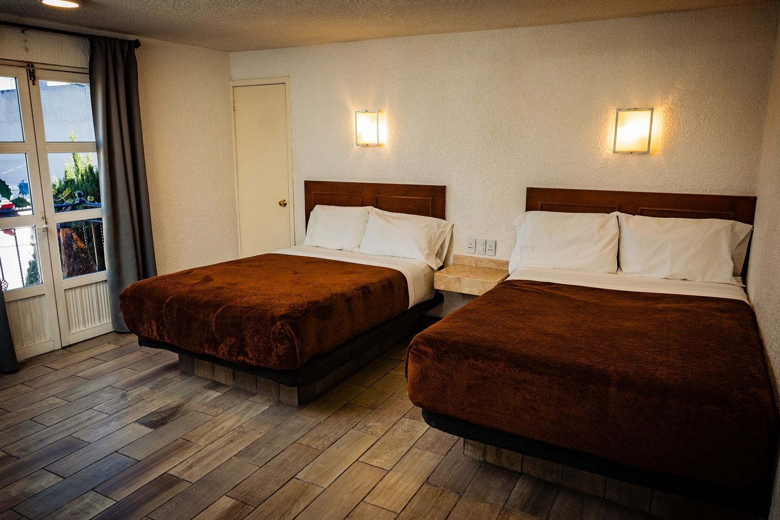 A hotel room with two beds and a window.