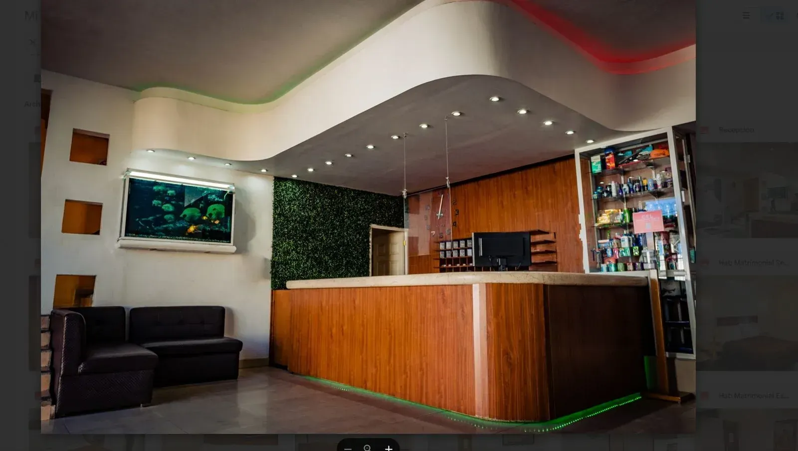 Un vestíbulo de hotel con un mostrador de madera y un sofá.