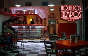 Un restaurante con un letrero de neón que dice aquellos tiempos cafe