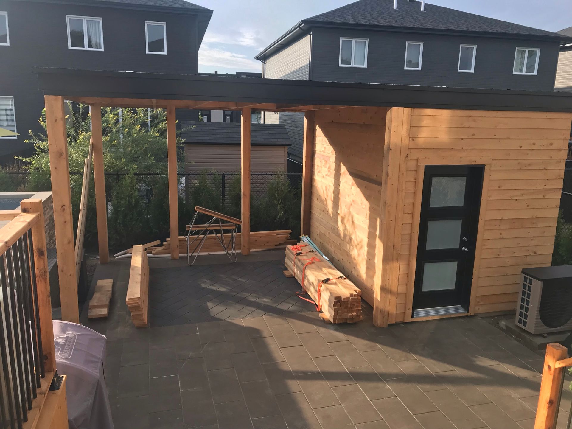 Un hangar en bois est en cours de construction dans la cour d'une maison.