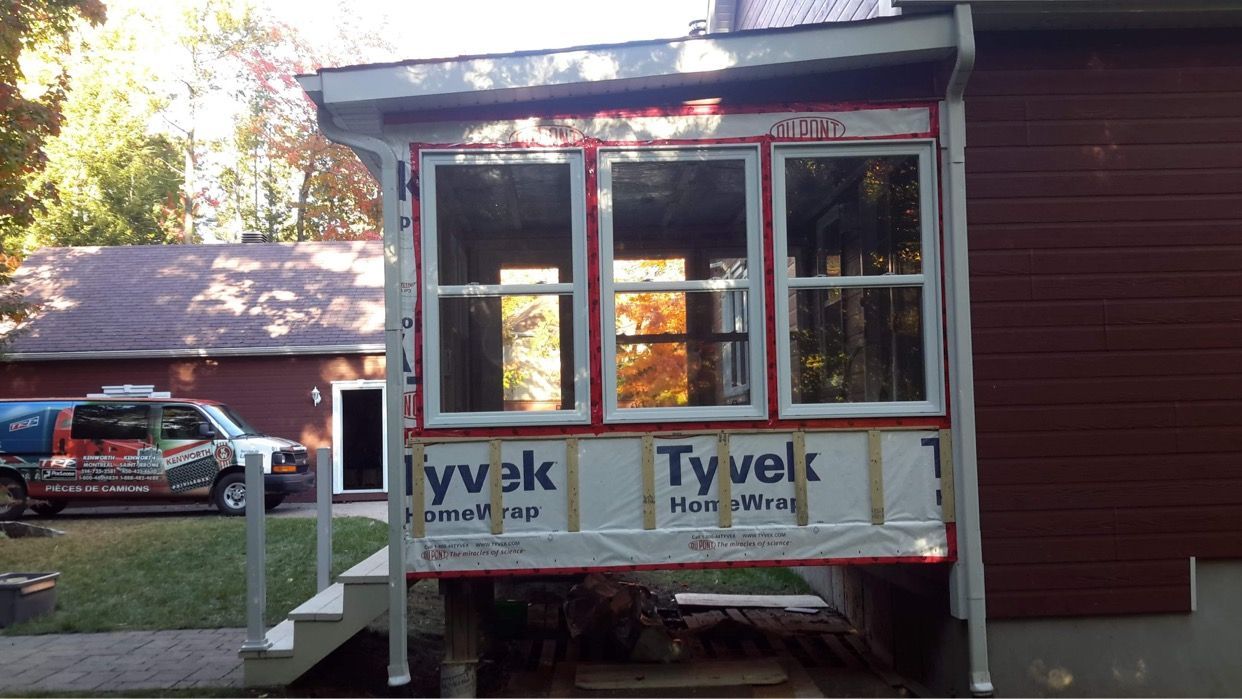 Une maison rouge avec une véranda et des escaliers