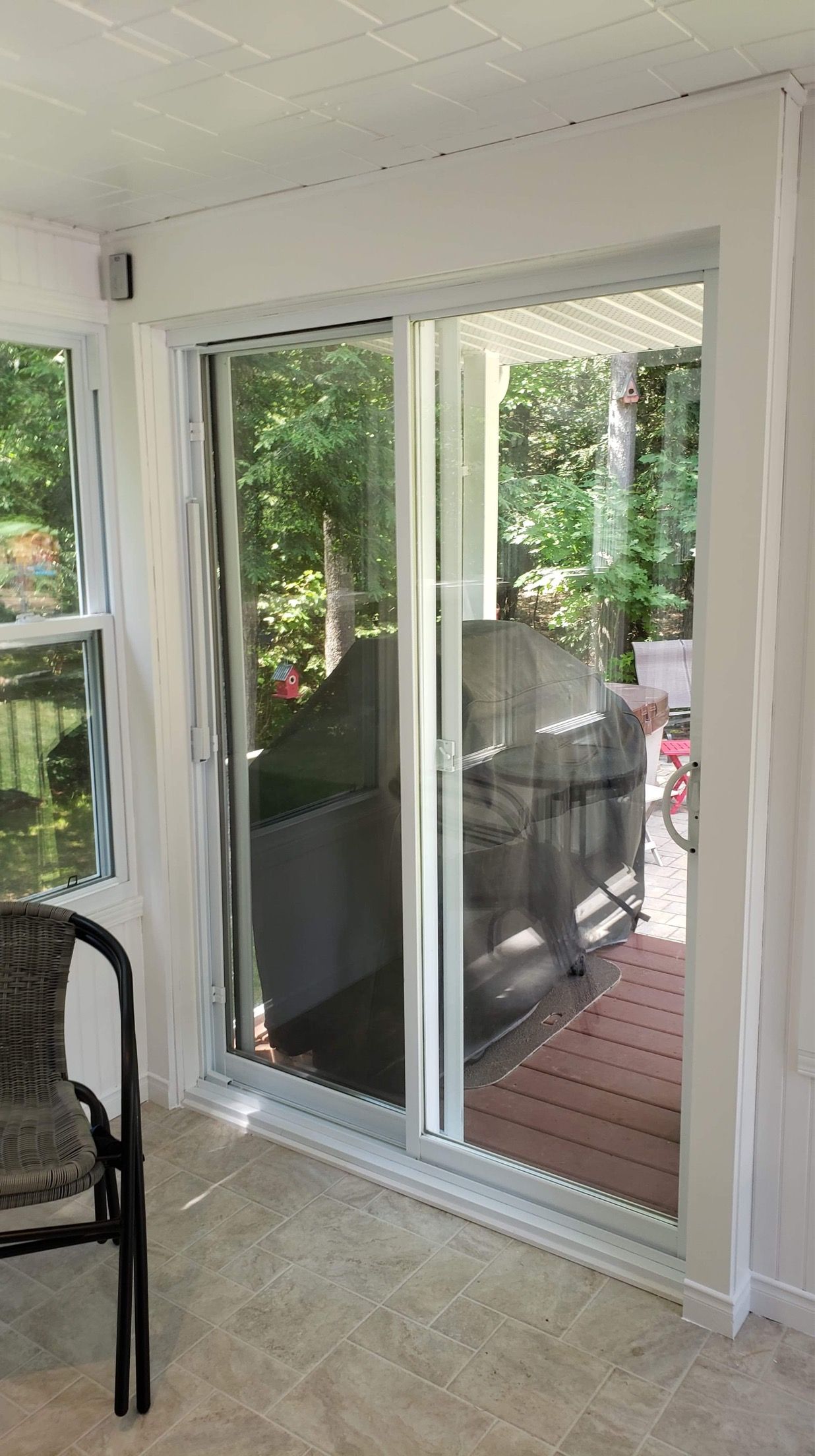 Un salon avec une porte vitrée coulissante et une chaise.