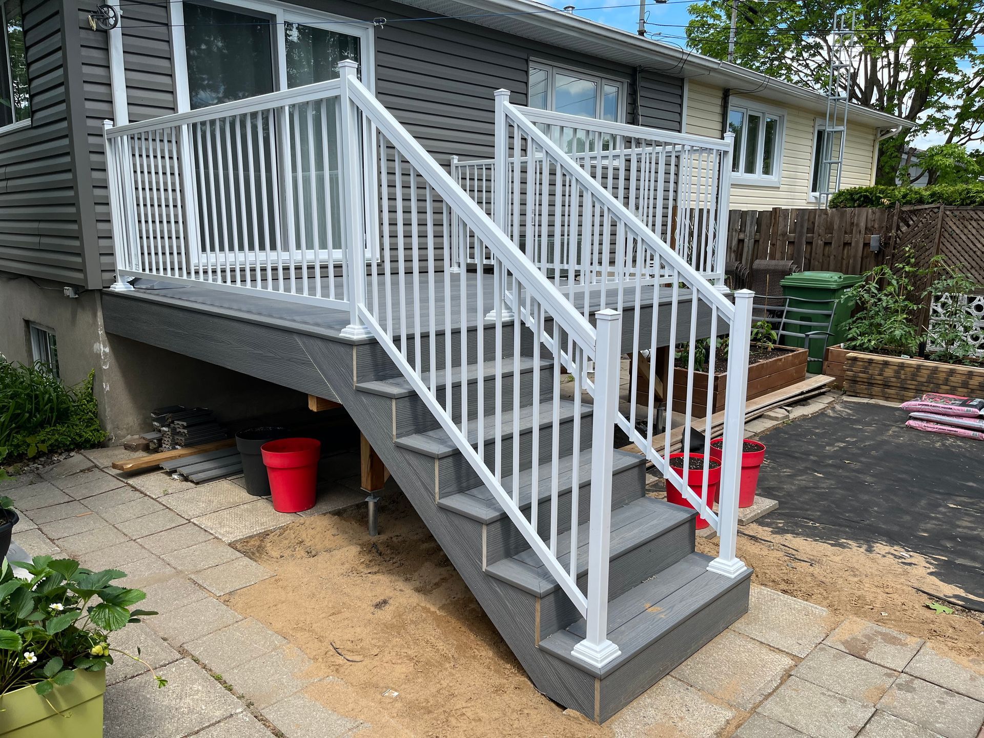 Une terrasse avec des escaliers qui y mènent et une balustrade blanche.