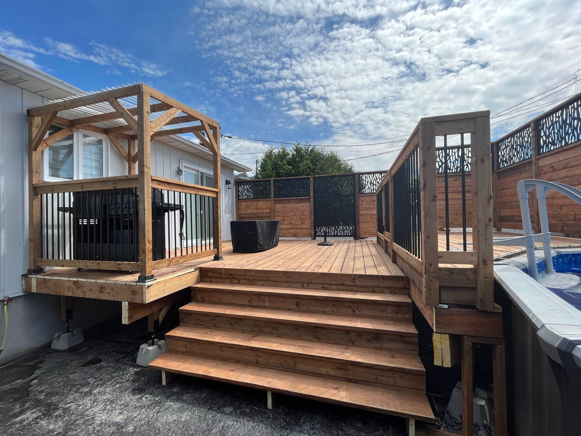 Une terrasse en bois avec des escaliers qui y mènent à côté d'une piscine.
