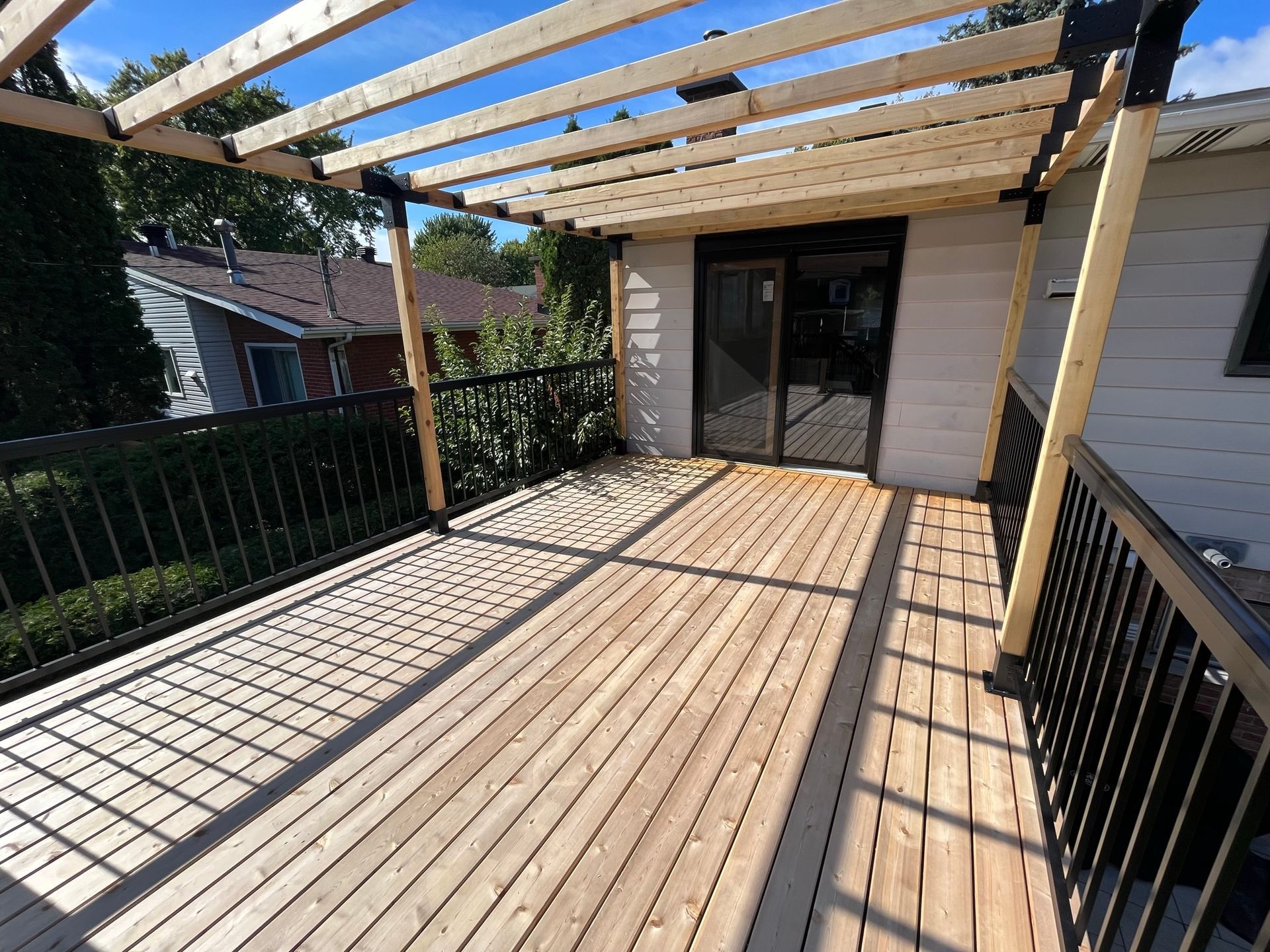 Une terrasse en bois avec une pergola au dessus