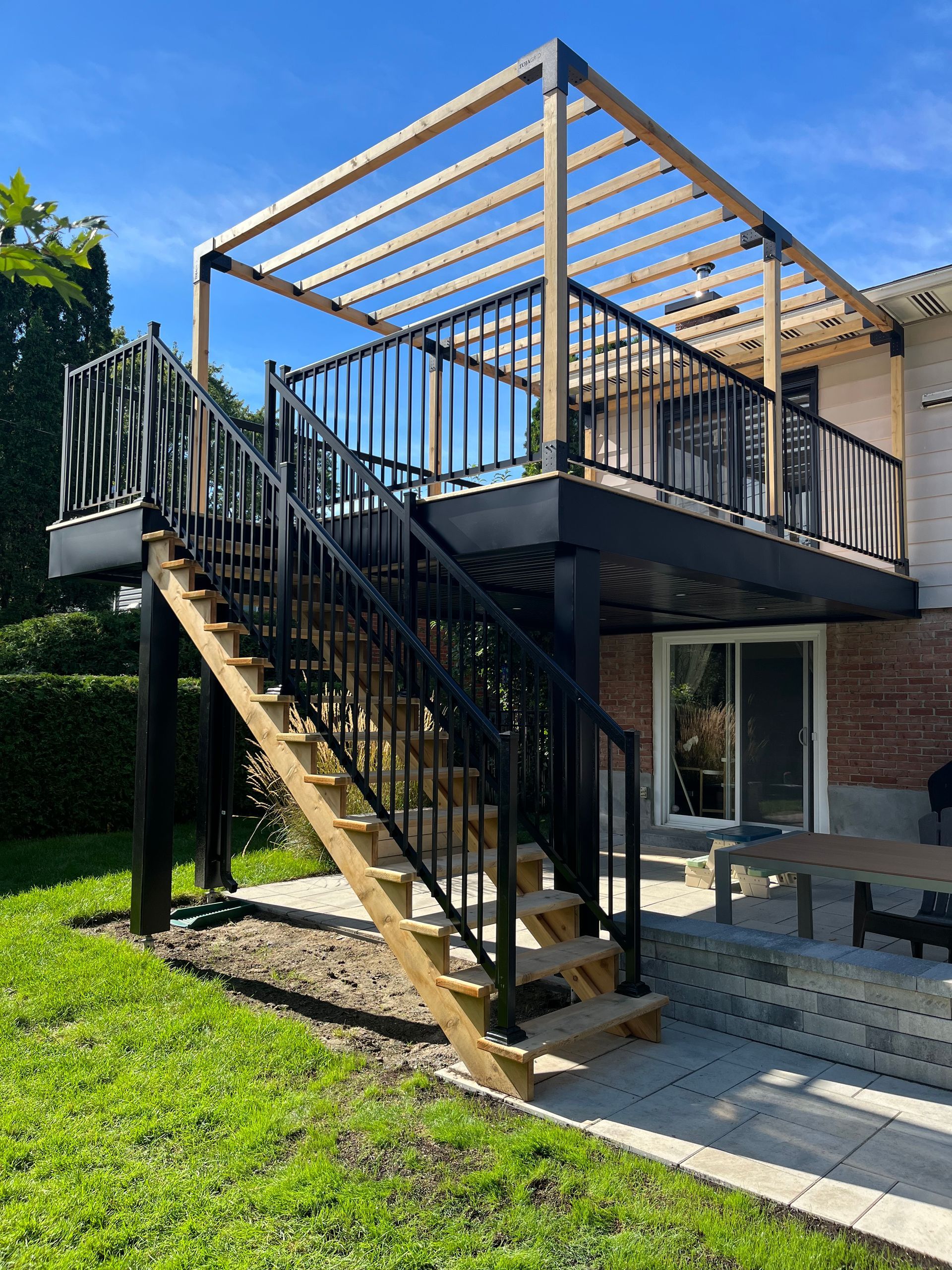 Une maison avec une terrasse et des escaliers qui y mènent.