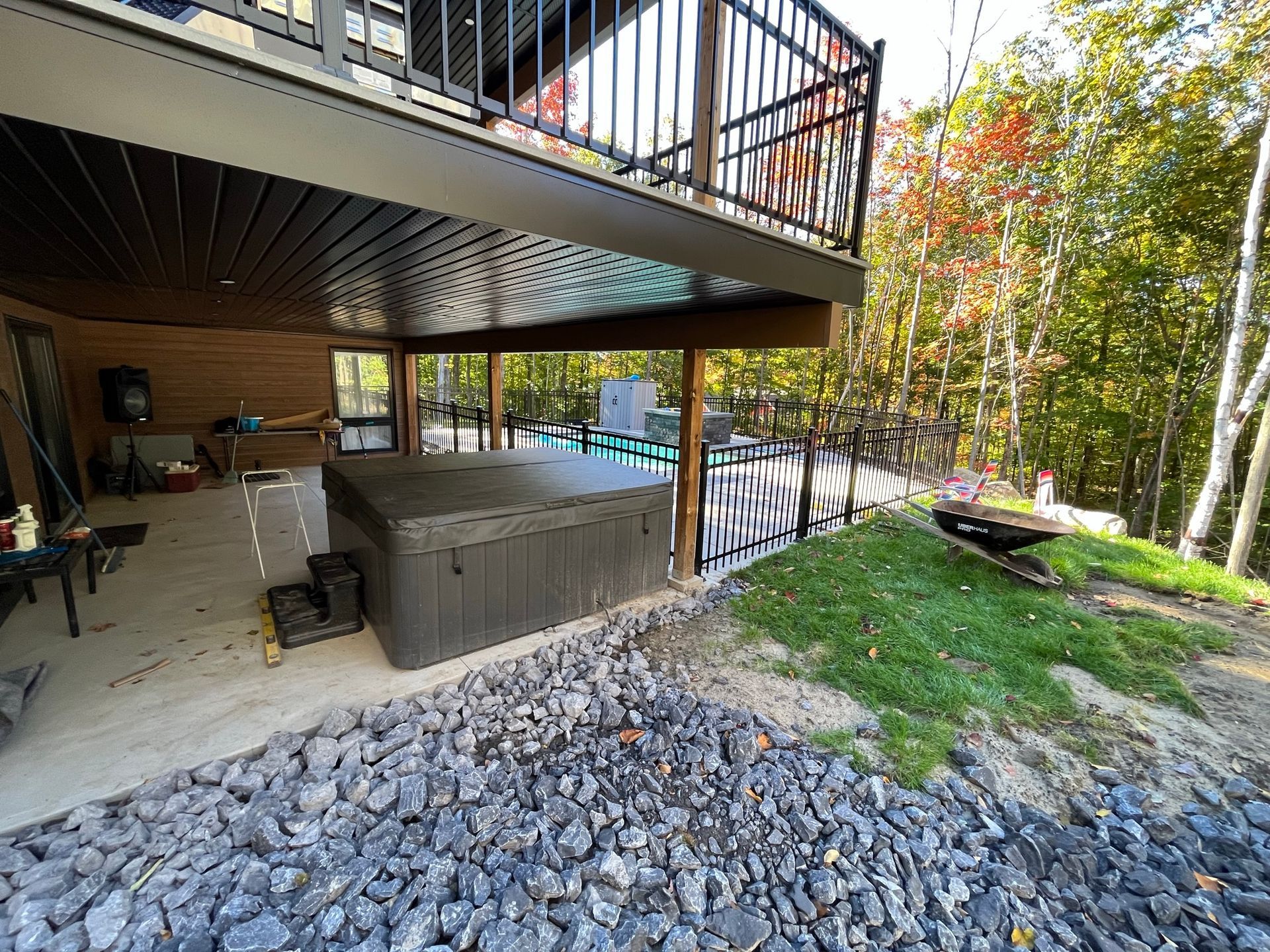 Il y a un bain à remous sous la terrasse d'une maison.