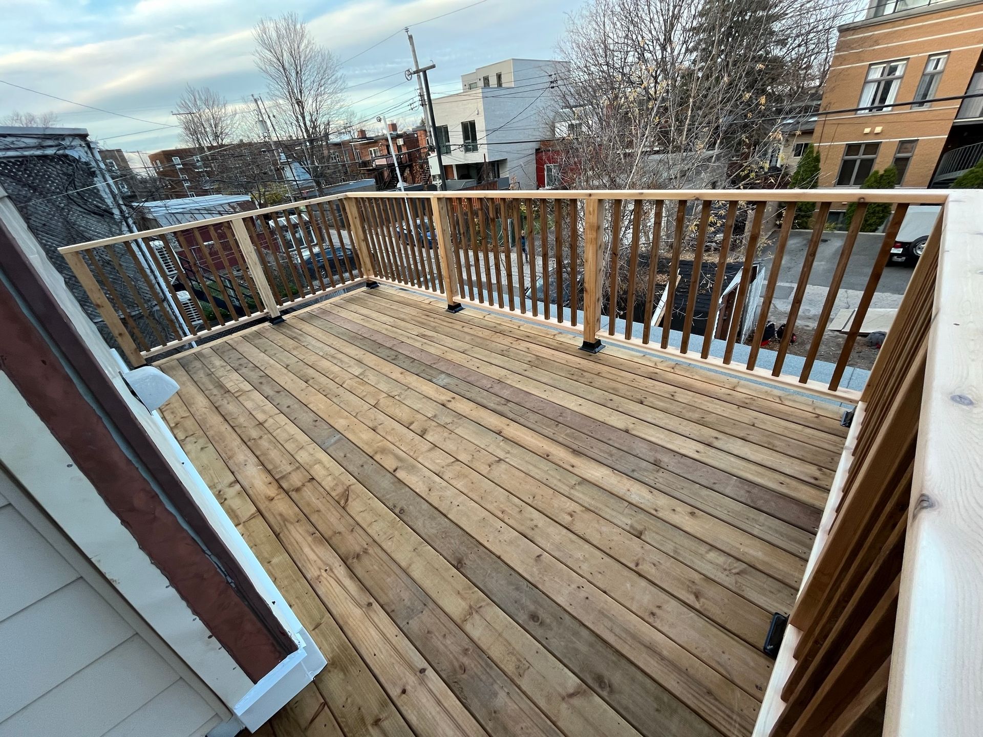 Une terrasse en bois avec une balustrade et une vue sur une ville.