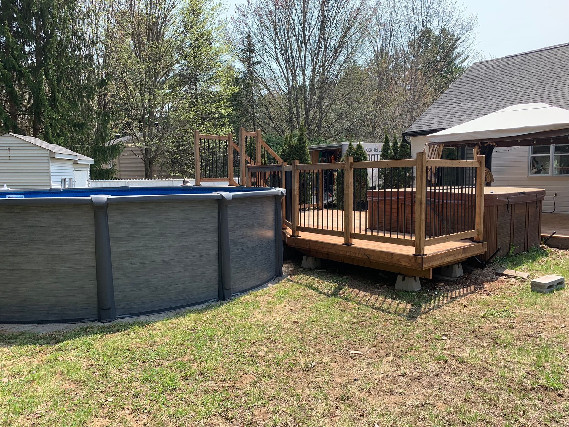 Une piscine se trouve à côté d'une terrasse en bois dans une cour.