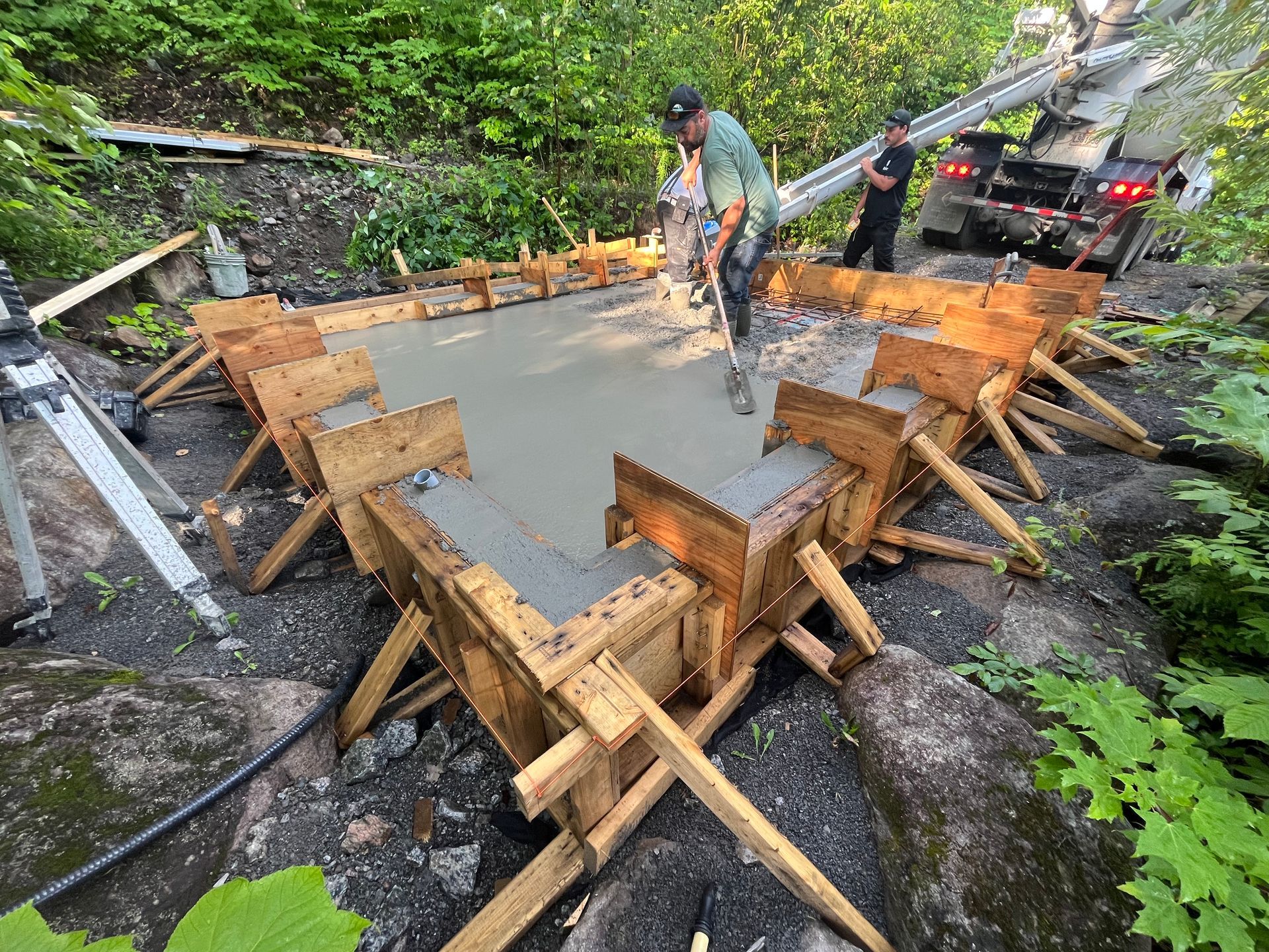 Un homme coule du béton dans une forme en bois.