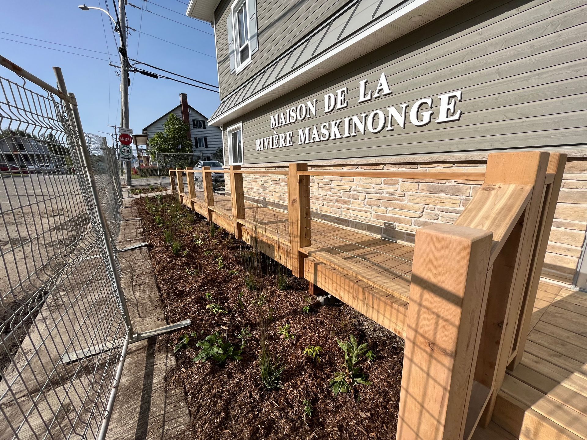 Un banc en bois est assis devant un bâtiment.