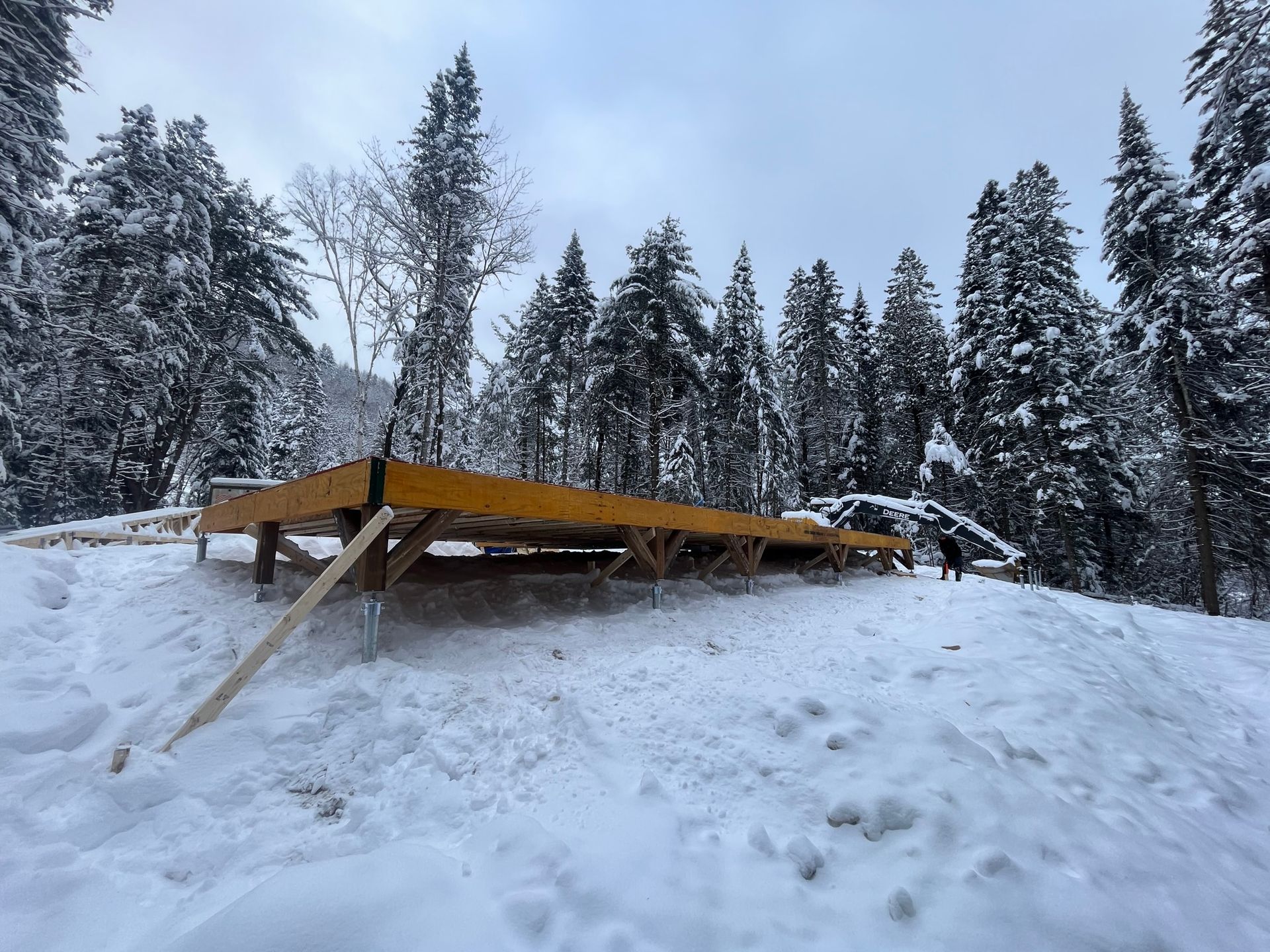 Une rampe en bois se trouve au milieu d'une forêt enneigée.
