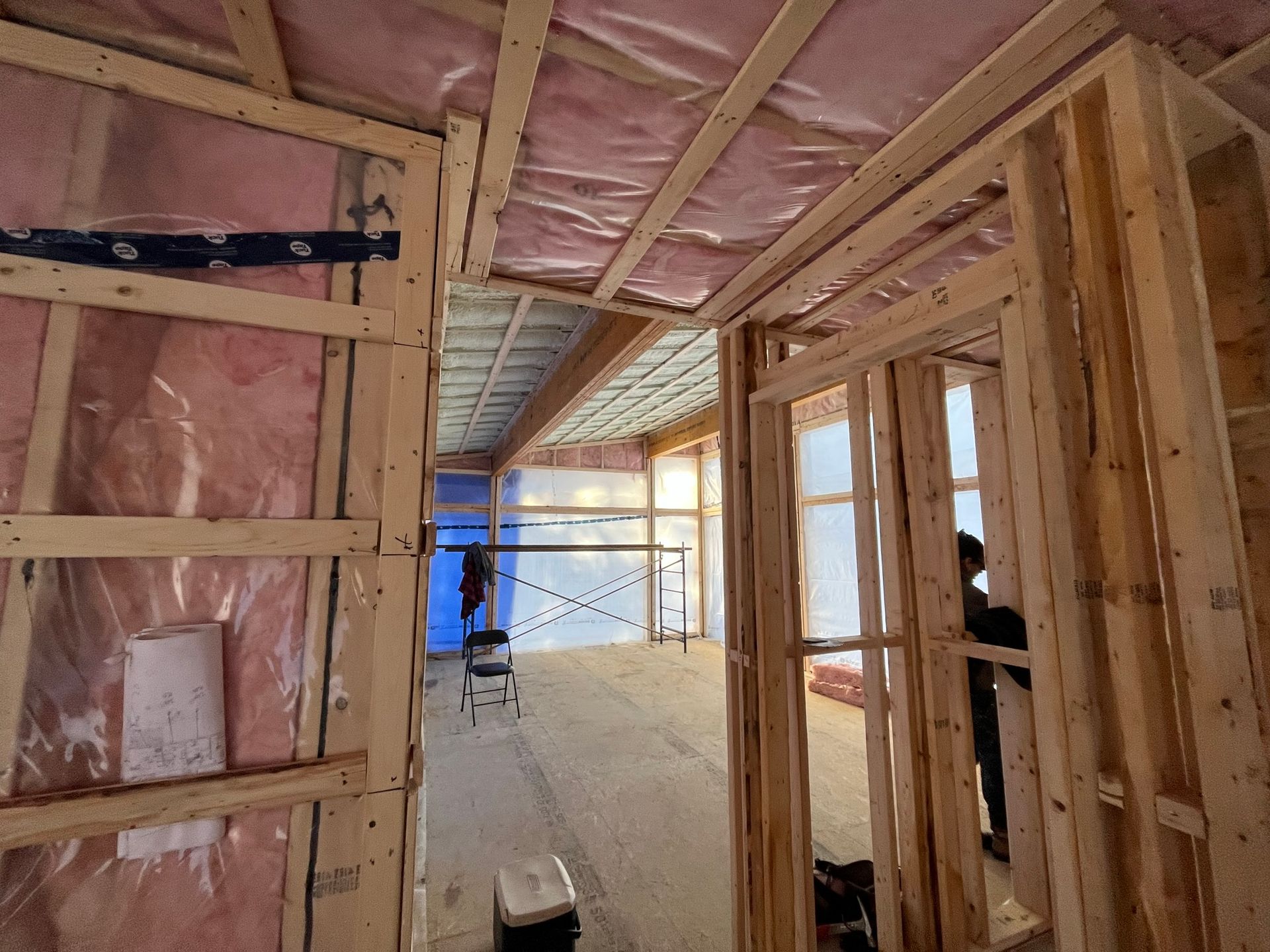 Une chambre dans une maison en construction avec beaucoup de bois et d'isolation.